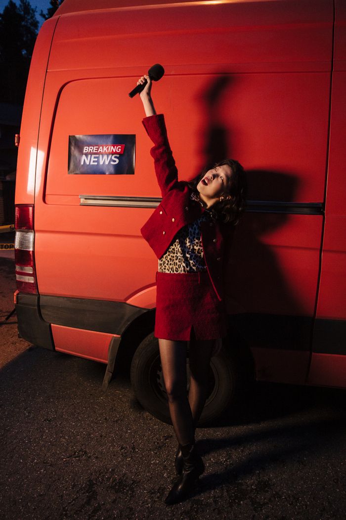 Mastering the First Impression: Your intriguing post title goes here Asian woman reporting news with raised hand and microphone against red van at night.